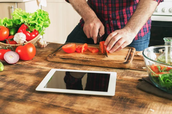 Homem procurando receita em tablet digital e cozinhar alimentos saudáveis — Fotografia de Stock