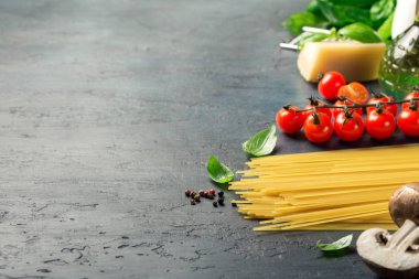 Karanlık bir yüzey üzerinde makarna yemek pişirmek için İtalyan malzemeler ayarla