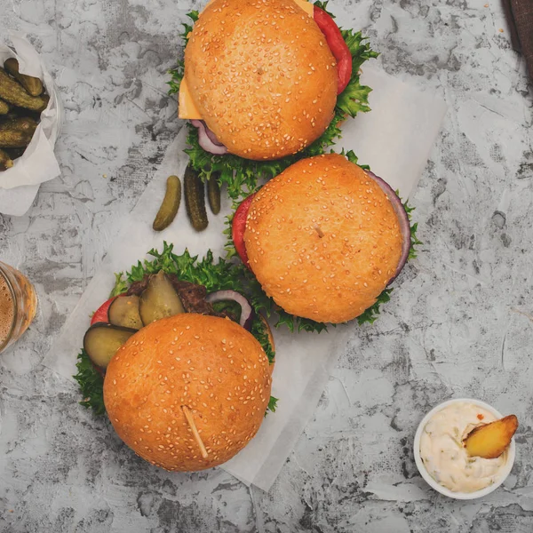 Trzy burger z frytkami na białej powierzchni — Zdjęcie stockowe