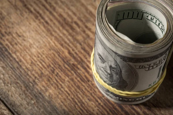 Rolo de dólar perto na mesa de madeira com espaço de cópia — Fotografia de Stock