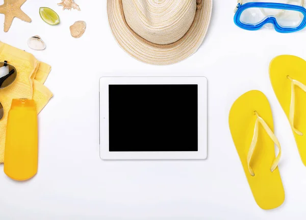 Variety beach accessories around tablet with copy space