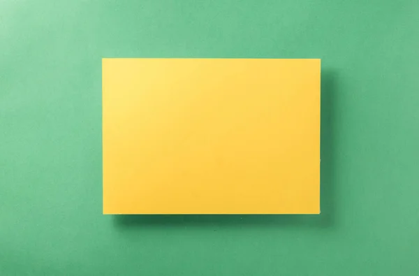 紙薄緑色の背景の黄色の空白のシート — ストック写真