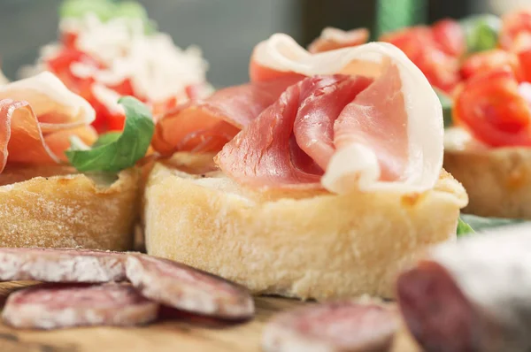 Close up bruschetta with prosciutto and basil — Stock Photo, Image