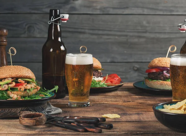 別のハンバーガー、スナック、木製のテーブルのラガービール — ストック写真