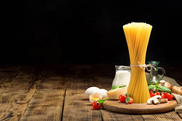 Esparguete italiano cru com ingredientes para cozinhar massas italianas — Fotografia de Stock