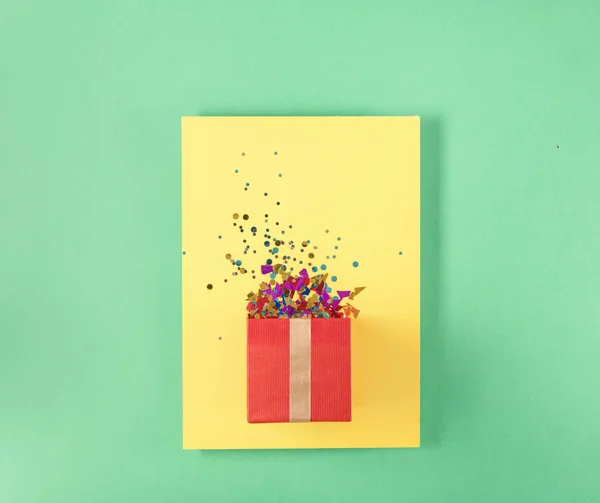 Confezione regalo rossa con confetti vari su cartellino giallo — Foto Stock