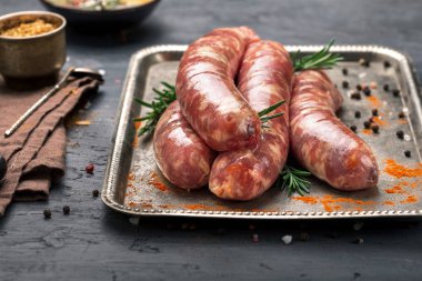 Karanlık yüzeyi demir tepside çiğ sosis ızgara