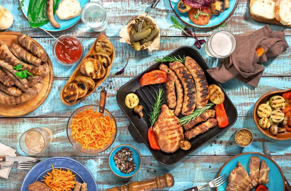 Rozmanitost jídla grilovaná na dřevěný stůl, pohled shora — Stock fotografie