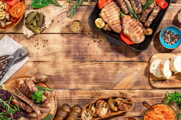 Rám z různých potravin grilu na dřevěný stůl — Stock fotografie