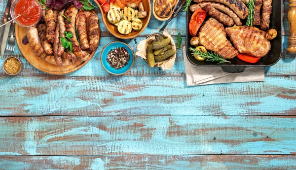 Variedade de alimentos grelhados na mesa de madeira azul — Fotografia de Stock