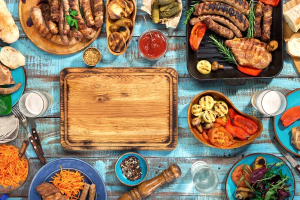 Kolem dřevěné krájecí desky různých jídla grilovaná na dřevěné kartu — Stock fotografie