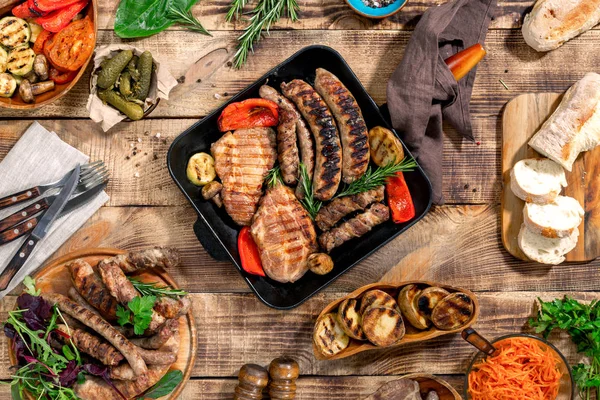 Steak grillé, saucisses grillées, légumes grillés sur le boisé — Photo