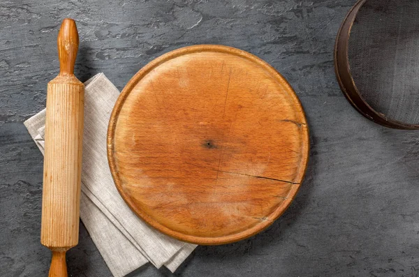 Круглая деревянная доска со скалкой, салфеткой, решетом — стоковое фото