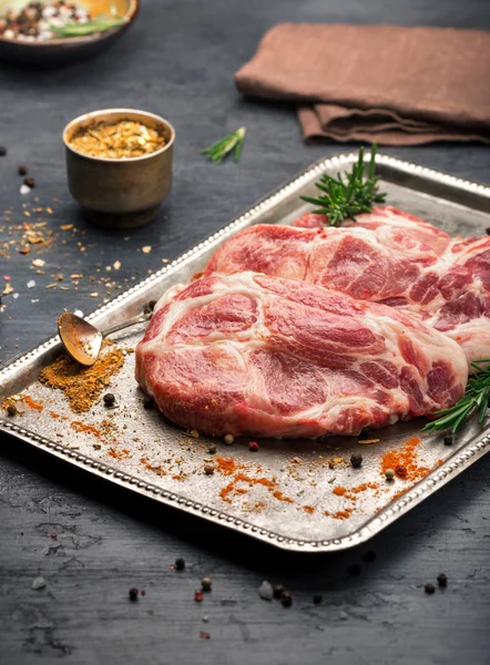 Jugoso pedazo de carne en bandeja de acero en la superficie oscura — Foto de Stock