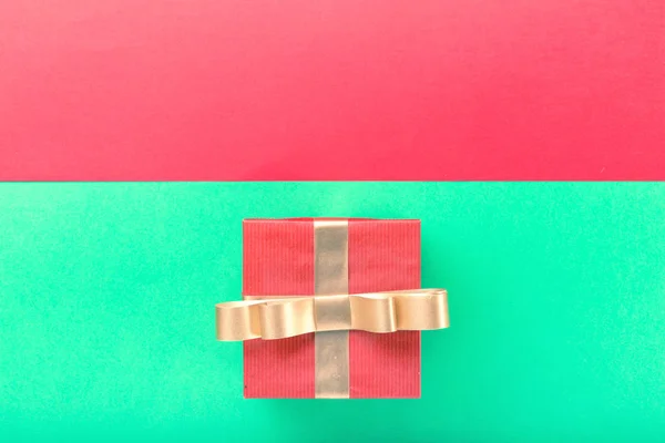 Altın şerit renkli bir arka plan üzerinde kırmızı hediye kutusu — Stok fotoğraf