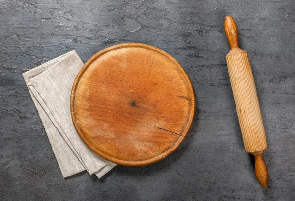 Round wooden board with rolling pin and cloth napkin