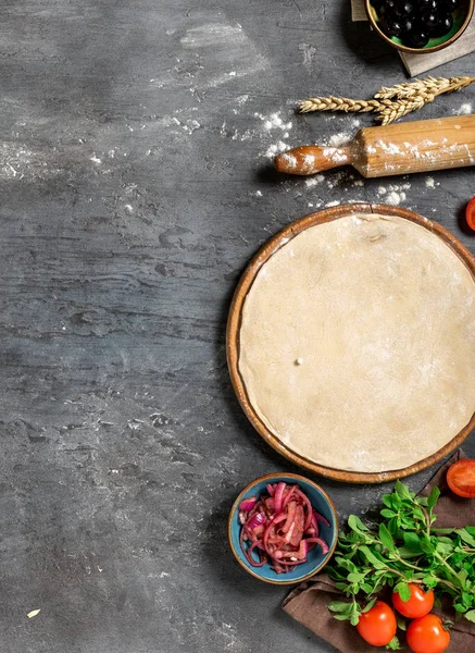 Raw pizza dough with ingredients for preparing vegetarian pizza — Stock Photo, Image