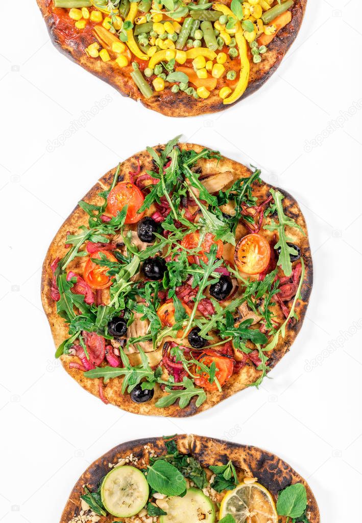 Three different vegan pizza on a white background