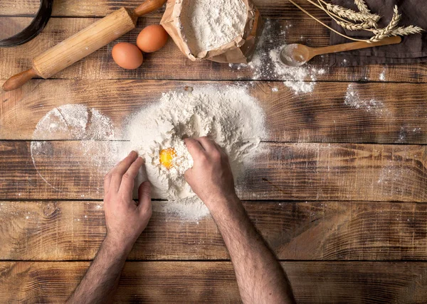 Mann kocht Brotteig auf Holztisch in Bäckerei — Stockfoto