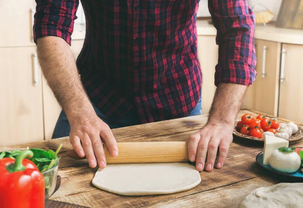 Man rolls out the dough for making homemade pizza — Stock Photo, Image