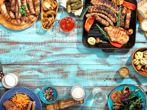 Comida diferente cozinhada na grelha na mesa de madeira azul — Fotografia de Stock