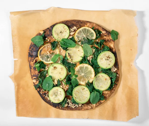 Закройте веганскую пиццу с цуккини, лимоном, шпинатом, грецкими орехами, мин — стоковое фото