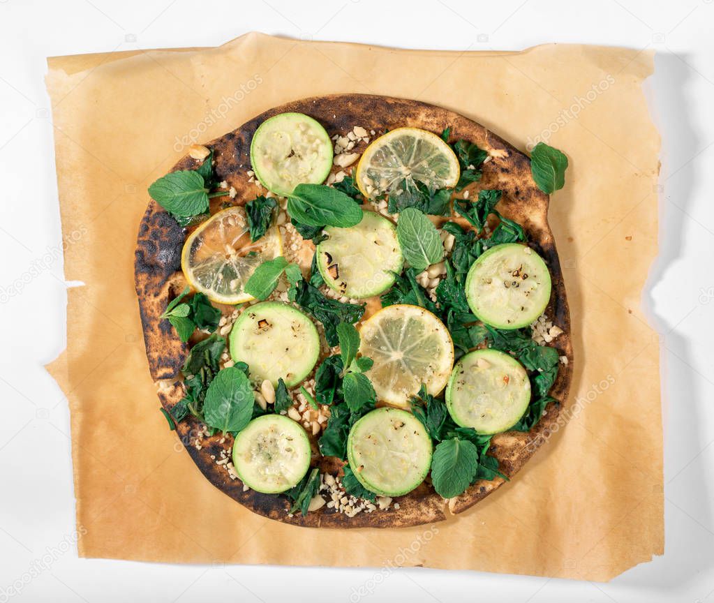 Close up vegan pizza with zucchini, lemon, spinach, walnuts, min
