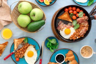 Sahanda yumurta, fasulye, domates, pastırma, tost çeşitli meyveler, meyve suyu, 