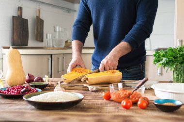 Erkek pirinç ve cranberries ile doldurulmuş kabak yemeği hazırlar