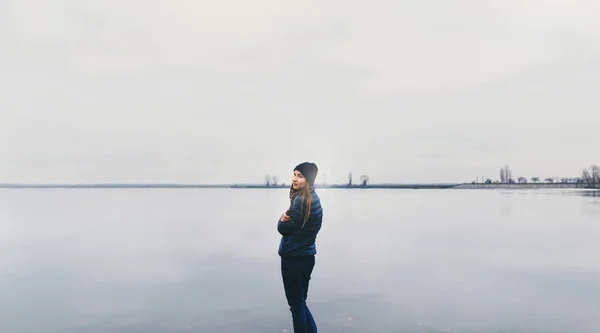 Счастливая молодая женщина стоит на реке — стоковое фото