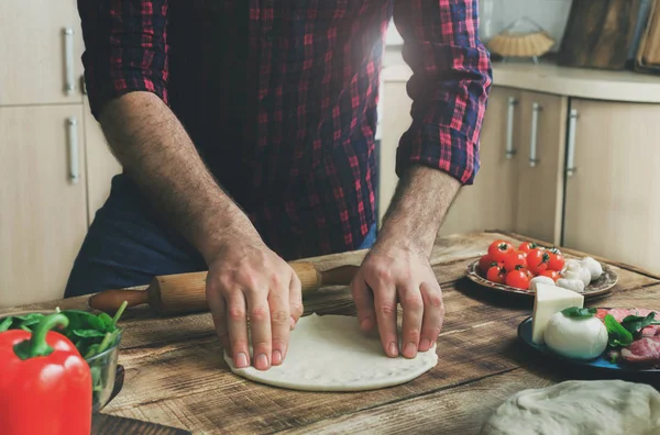 Ο άνθρωπος προετοιμασία ζύμης για μαγείρεμα σπιτικό πίτσα στην κουζίνα στο σπίτι — Φωτογραφία Αρχείου