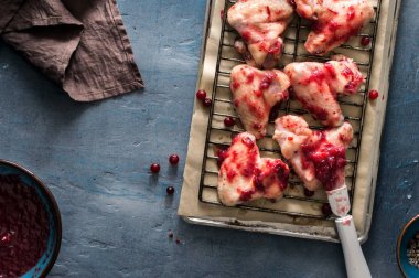 Kara taş yüzeyi kızılcık sosu içinde çiğ tavuk budu