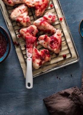 Kara taş yüzeyi kızılcık sosu içinde çiğ tavuk budu