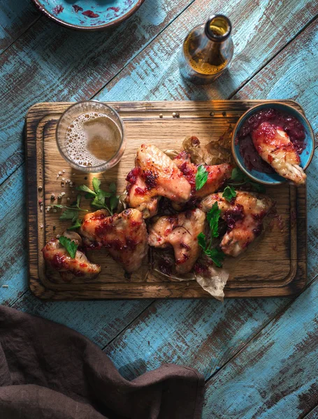 Chicken wings in cranberry sauce with lager beer — Stock Photo, Image