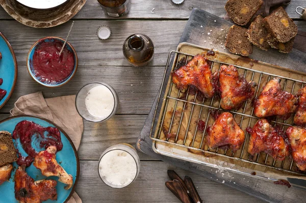 Chicken wings with beer on rustic wooden table — Stock Photo, Image