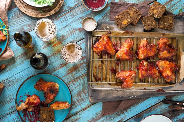 Chicken wings in cranberry sauce with lager beer — Stock Photo, Image