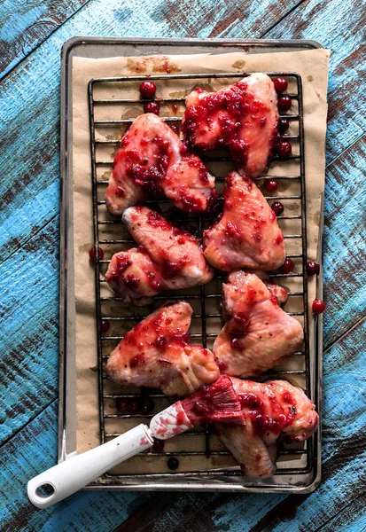 Raw chicken wings in cranberry sauce on baking sheet — Stock Photo, Image