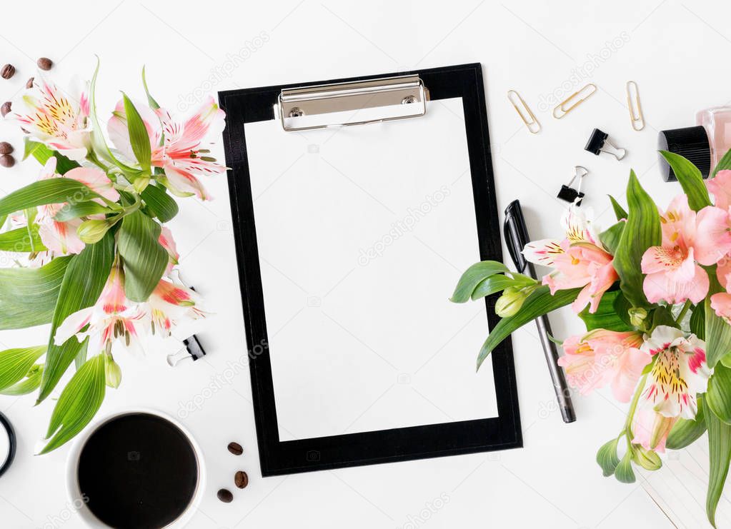 Workspace with clipboard, office accessories, coffee and bouquet