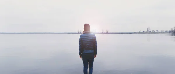 Женщина, стоящая на берегу реки — стоковое фото