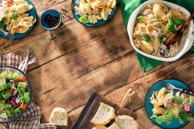 İtalyan makarna salata ahşap masa üzerinde çerçeve