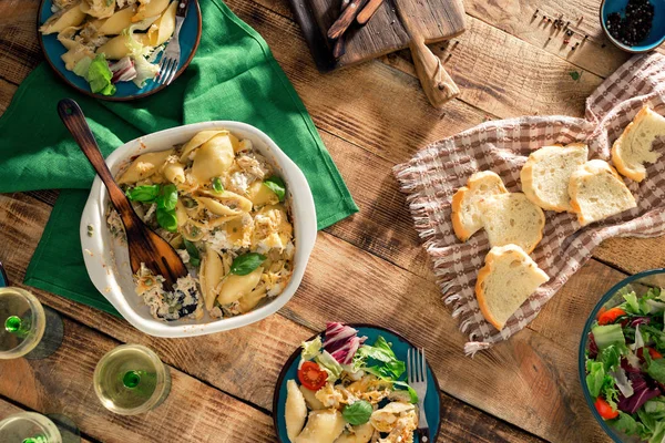 Eettafel met Italiaanse pasta, salade en wijn, bovenaanzicht — Stockfoto