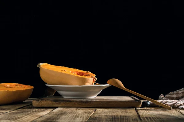 暗い背景に木製のテーブルの上皿で新鮮なカボチャ — ストック写真