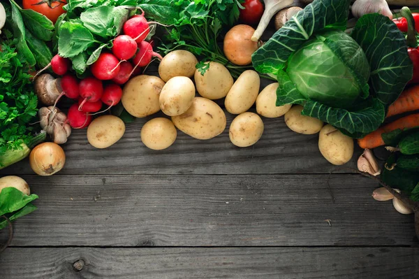 Zestaw świeżych warzyw na drewnianym stole z granicy — Zdjęcie stockowe