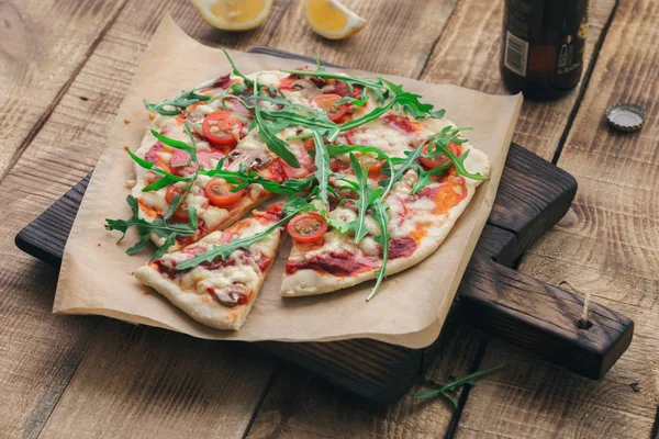 Pizza italiana en el tablero de madera con cerveza de cerca —  Fotos de Stock