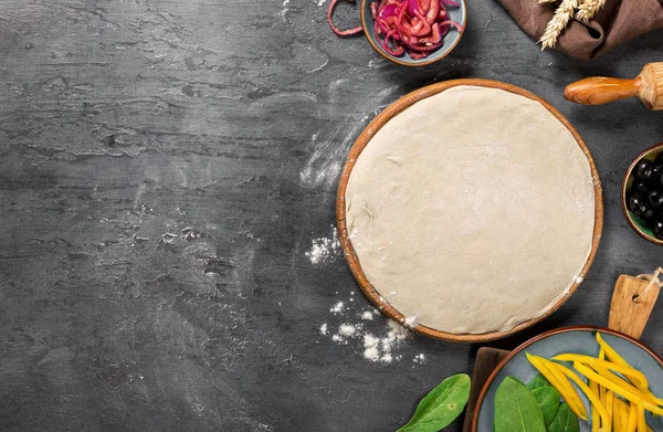 Свежее тесто с ингредиентами для приготовления вегетарианской пиццы — стоковое фото