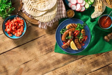 Izgara sosis ile yemek masası, tortilla saran ve farklı 