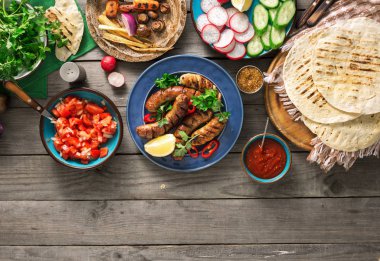 Izgara sosis ile yemek masası, tortilla saran ve farklı 