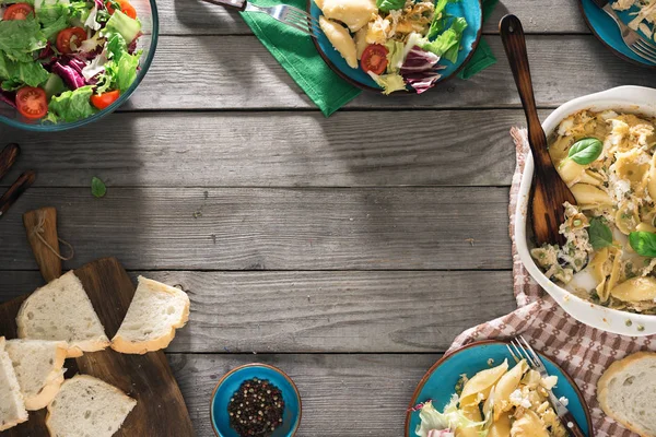 Frame van Italiaanse pasta en salade op houten tafel — Stockfoto