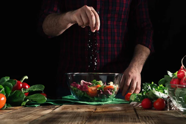 Homem polvilha salada de sal — Fotografia de Stock