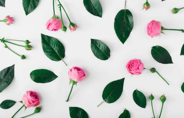 Plano leigos padrão floral feito de rosas e folhas cor de rosa — Fotografia de Stock